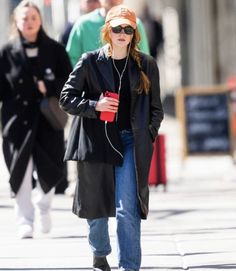 a woman walking down the street with headphones on