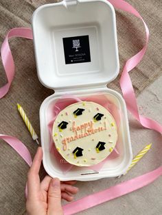 a cupcake in a box with a pink ribbon around it and a happy birthday message on the inside