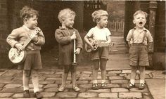 three children with musical instruments standing in front of a sign that says tu acttud