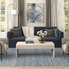 a living room with couches, chairs and a coffee table in front of two windows