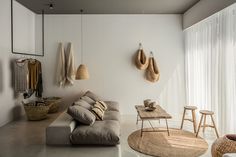 a living room filled with lots of furniture and hanging items on the wall next to a window