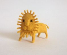 a small yellow toy lion on a white surface