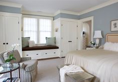 a bedroom with blue walls and white furniture