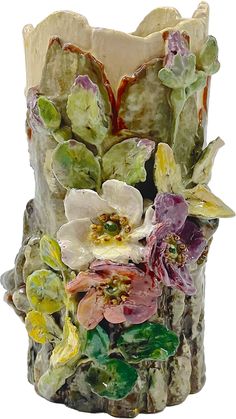 a vase with flowers and leaves painted on the outside, sitting in front of a white background