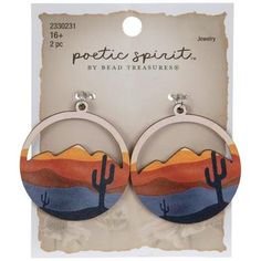 a pair of earrings with an image of a desert scene on the front and back