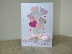 a card with hearts and pink ribbon on it that says, sending you a bunch of love