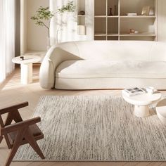 a living room with a white couch and coffee table in front of a bookshelf