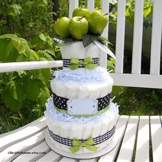 a diaper cake sitting on top of a wooden table next to some green apples