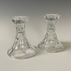 two clear glass candlesticks sitting side by side