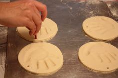 hand prints on doughnuts being made by someone using a spatula to make them