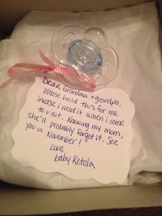 a baby pacifier in a box with a note attached to the end of it