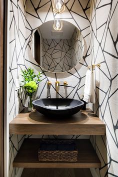 a bathroom sink with a black bowl on top of it next to a wooden counter