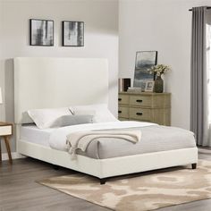 a white bed sitting on top of a wooden floor