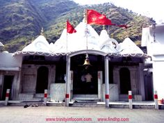 an ornate white building with red flags on top