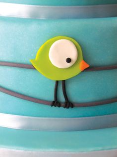 a blue cake with a green bird on top