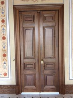 two wooden doors in an ornately decorated room