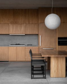 a kitchen with wooden cabinets and black chairs