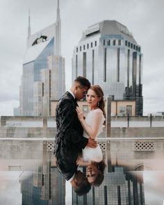 a man and woman standing next to each other in front of a cityscape