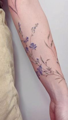 a woman's arm with purple flowers on it