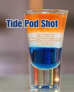 an orange and blue liquid in a glass with the words tide pod shot on it