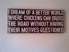 a wooden sign that reads, dream of a better world where chickens can cross the road without having their motives questions