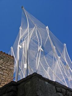 an artistic sculpture on the side of a building with blue sky in the back ground