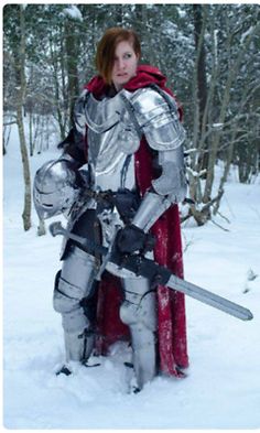 a woman dressed as a knight standing in the snow