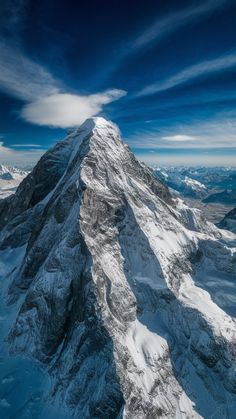 an aerial view of the top of a snow - capped mountain with clouds in the sky