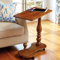 a wooden table sitting on top of a hard wood floor next to a white couch