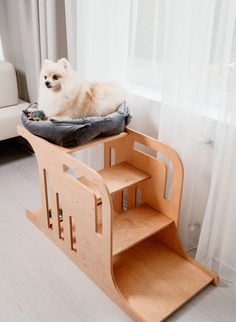 a small dog laying on top of a wooden pet bed