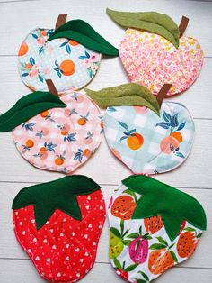 four pieces of fabric with different designs on them and one has a green leaf, the other is a strawberry