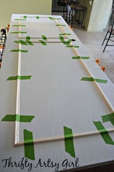 the table is covered with green tape and white boards that are taped together to form an arrow pattern