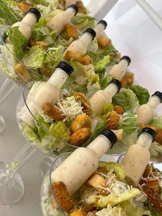 several salads with dressing on them are lined up in glass bowls and ready to be eaten