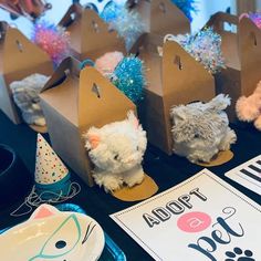 there are several stuffed animals on display at the table with their name tags and party hats