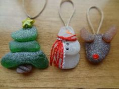 three christmas ornaments sitting on top of a wooden table