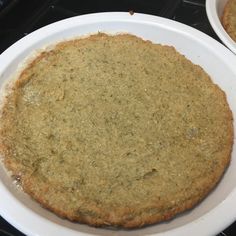 two white plates with food on them sitting on a stove top next to each other