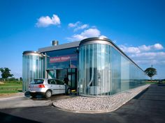 a car is parked in front of a glass building