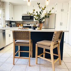 two chairs sitting in front of a kitchen island with flowers on the counter and an oven