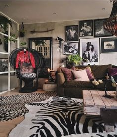 a living room with zebra print rugs and pictures on the wall behind the couch