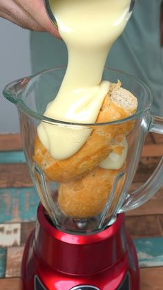 a person pouring cream into a blender filled with doughnuts and other items