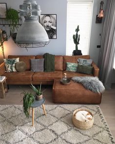 a living room with a brown couch and some plants on the table in front of it