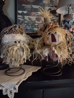 two scarecrows are sitting on a table next to a lamp and other items