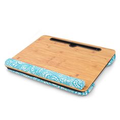 a wooden cutting board with a blue and white design on the bottom, along with a black handle