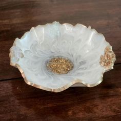 a white bowl sitting on top of a wooden table next to a brown and white object