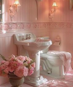 a bathroom with pink walls and flowers in the bathtub on the floor next to the toilet