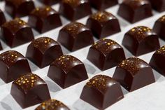 several pieces of chocolate with gold flecks on them sitting on a white surface