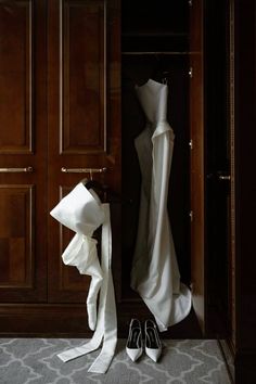 a wedding dress and shoes sit in the closet next to each other on a rug