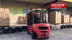 a red forklift parked in front of a warehouse