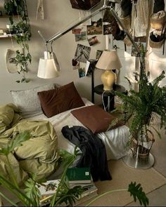 a bedroom with lots of plants and pictures on the wall