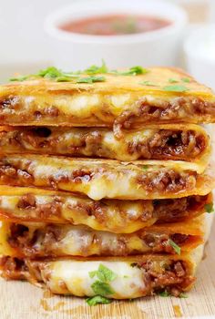 stack of cheese and meat quesadillas on wooden cutting board